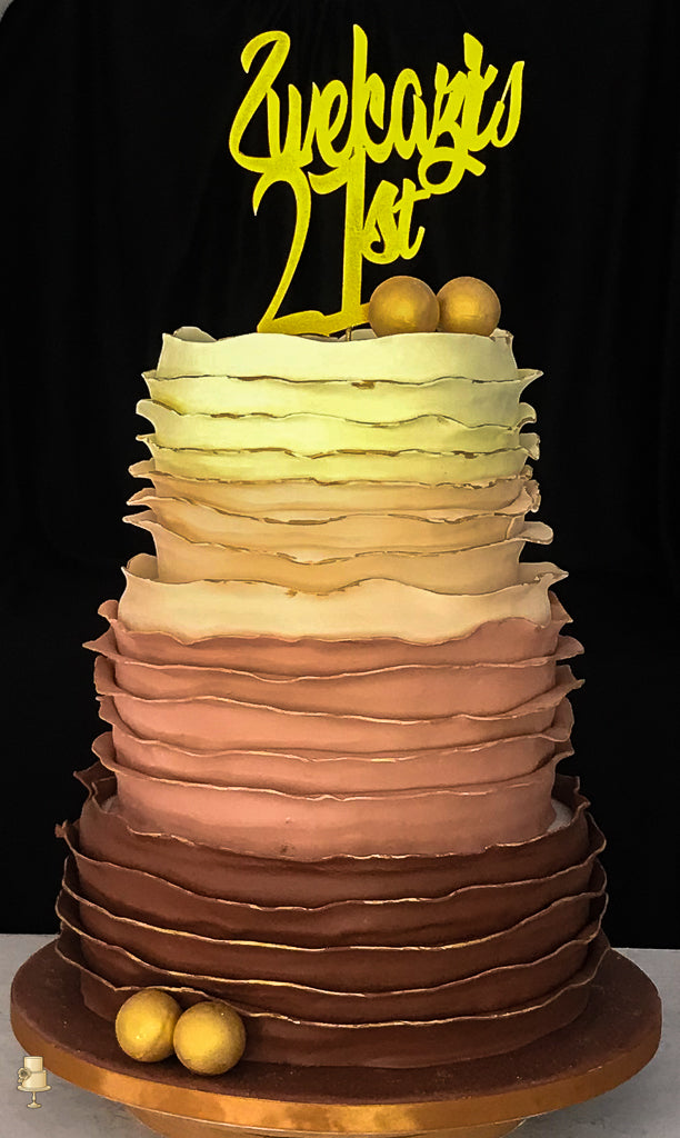 Multilayered cake with ruffled frosting and '21st' topper on a black background
