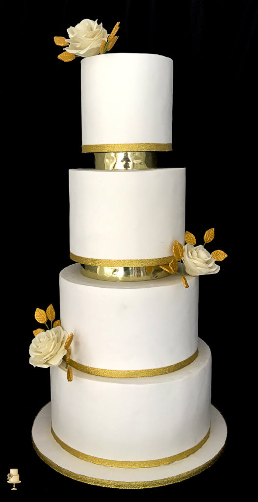 White wedding cake with gold accents and roses on a black background