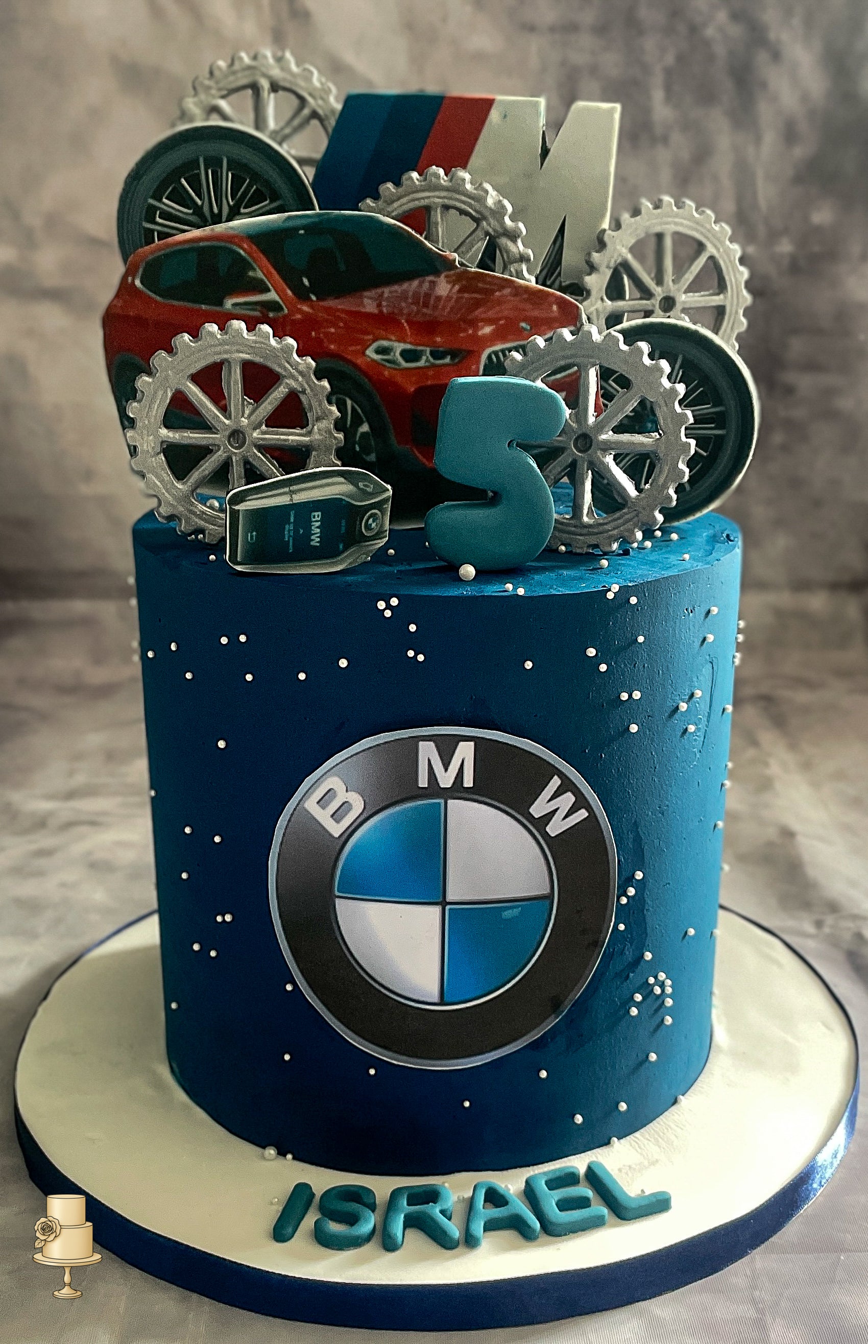 Cake with BMW logo and car model on a gray background