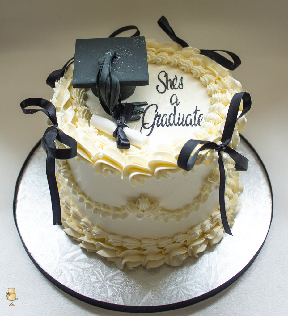 Graduation themed buttercream cake with fondant cap and scroll.