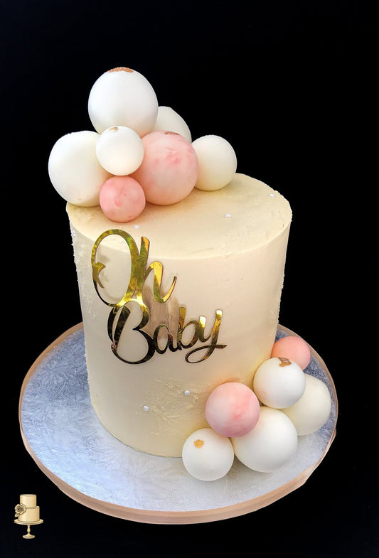 Baby shower cake with decorative balls and cake topper