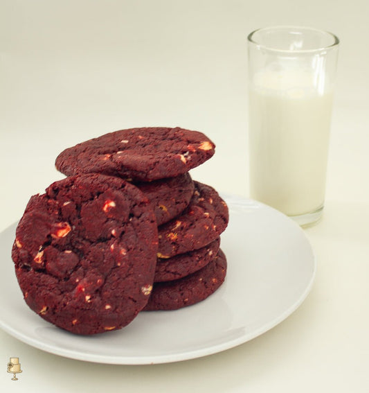 Red velvet cookies with white chocolate on a plate with glass of milk
