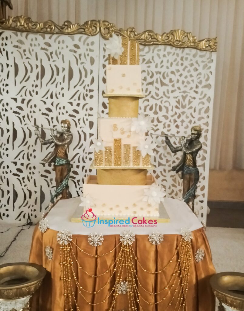4 tier square cream and gold cake with separators