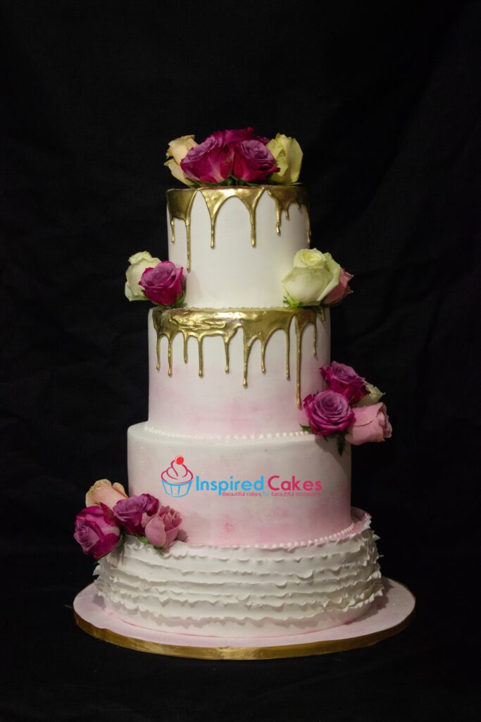 4 tier gold drip wedding cake with fresh roses